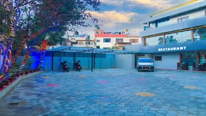 A restaurant with a modern design, a covered outdoor seating area, and a paved courtyard.