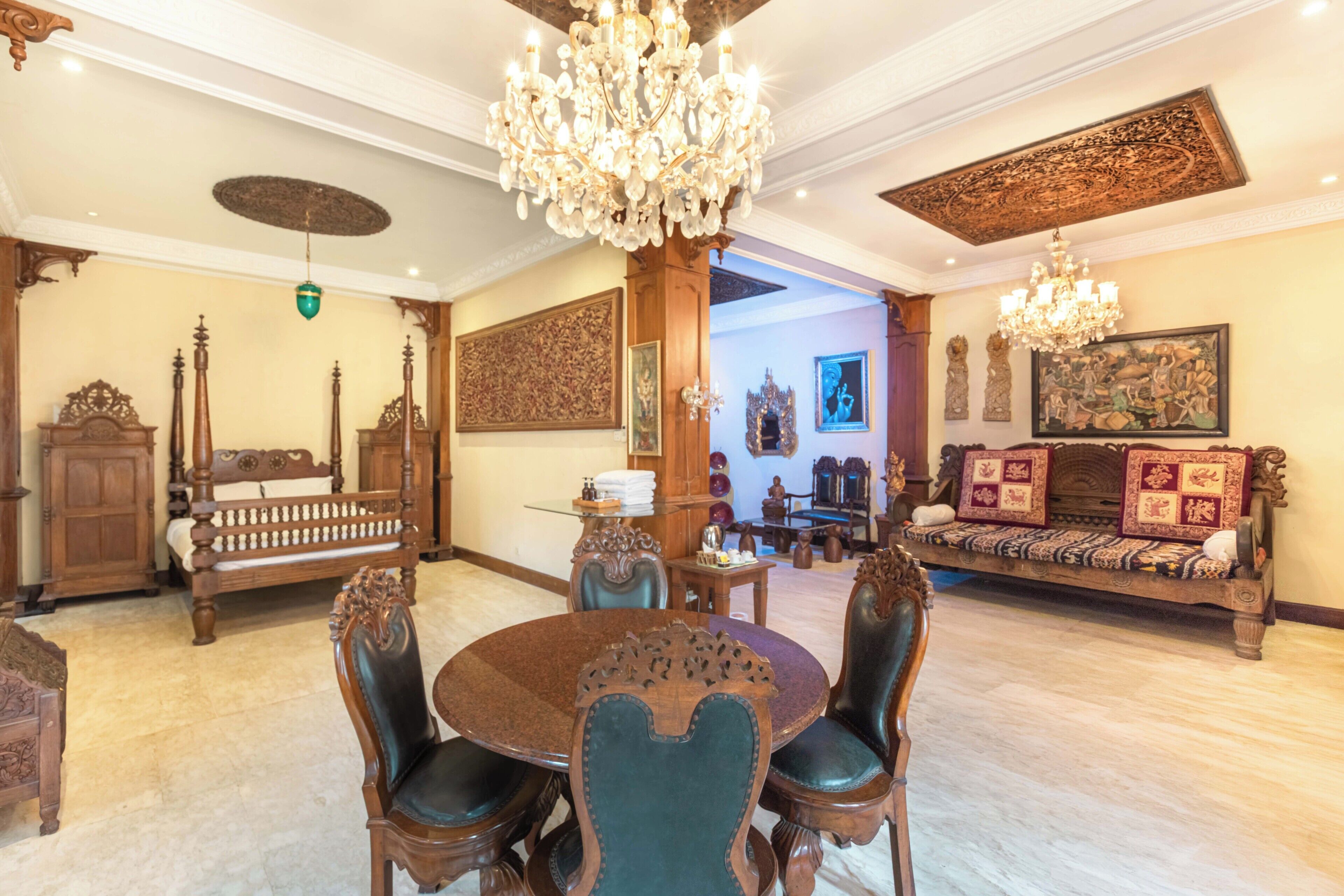 A dining area with a round table, chairs, and a chandelier.