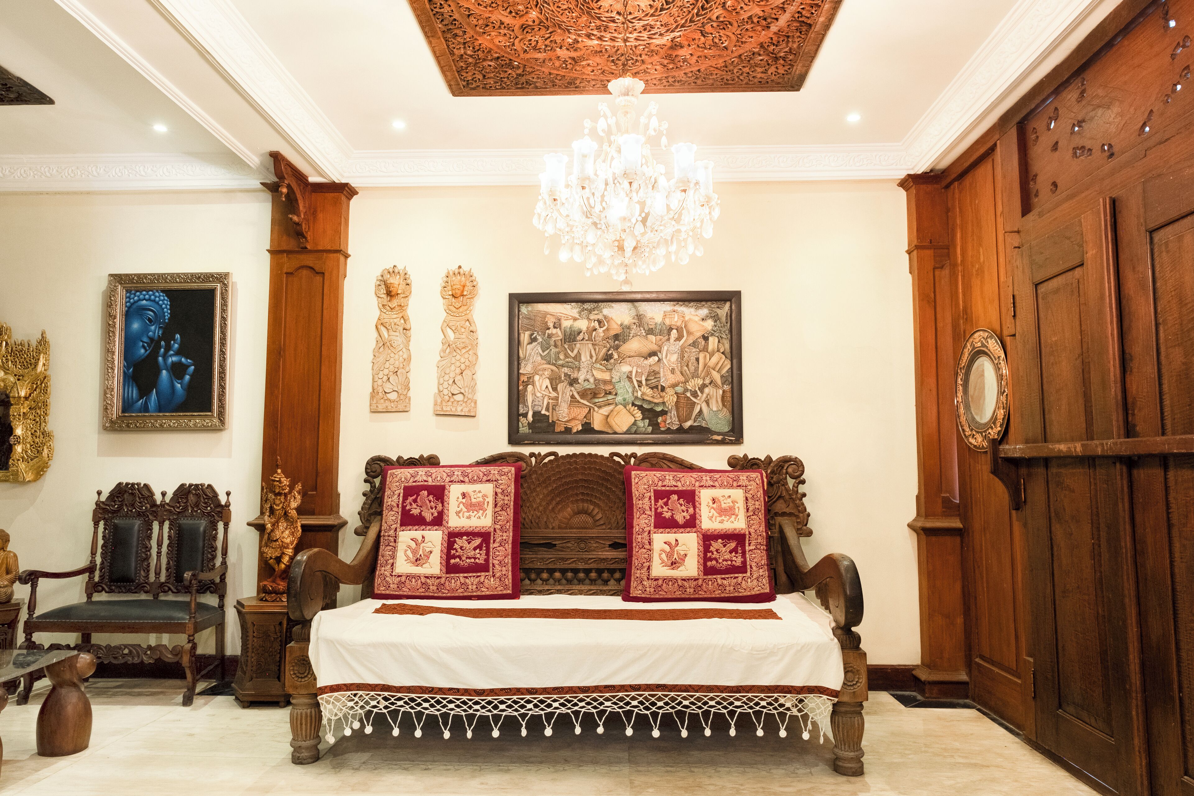 A traditional room with a wooden bed, a chandelier, and artwork on the walls.