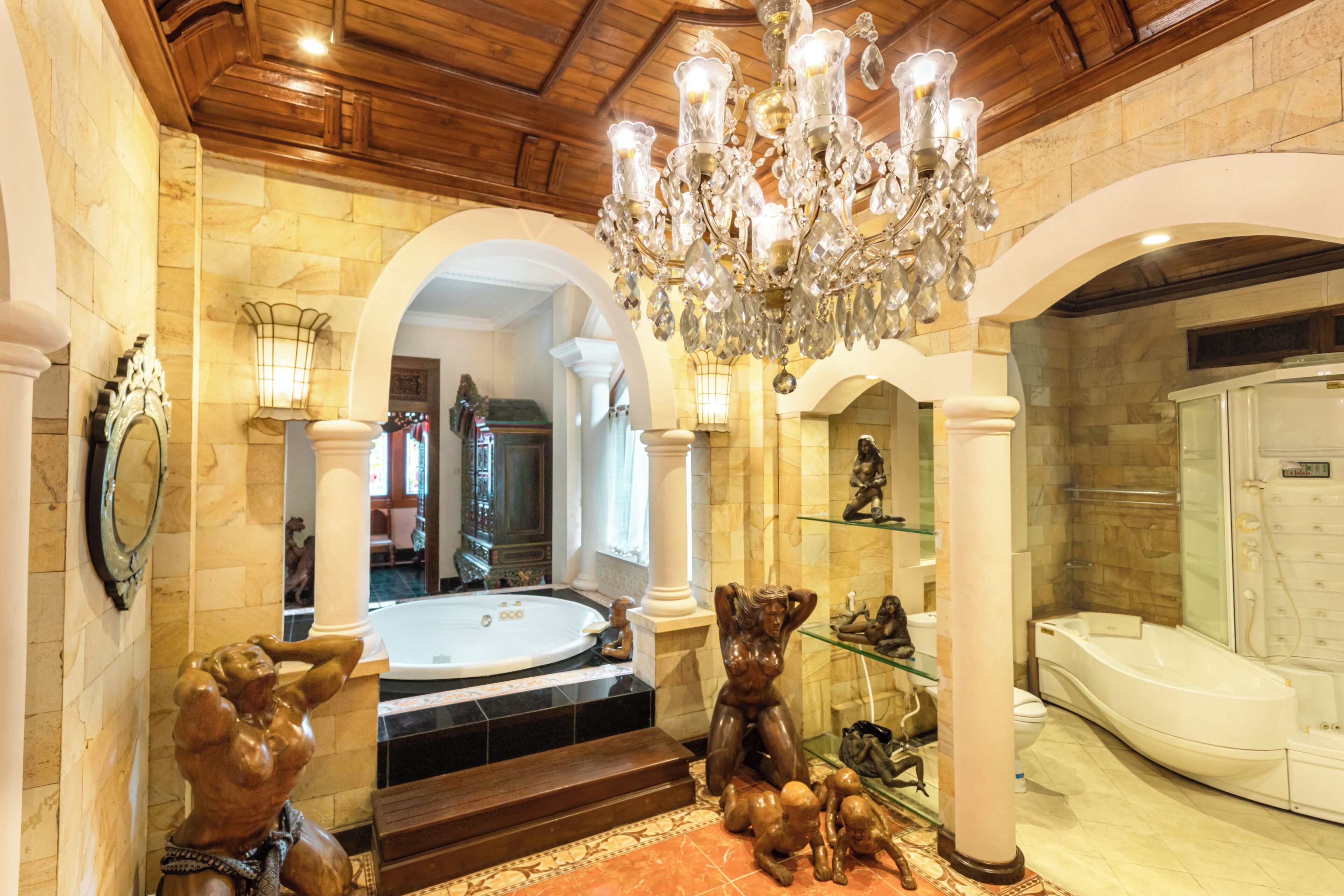 A luxurious bathroom with a large bathtub, a shower, and a chandelier.