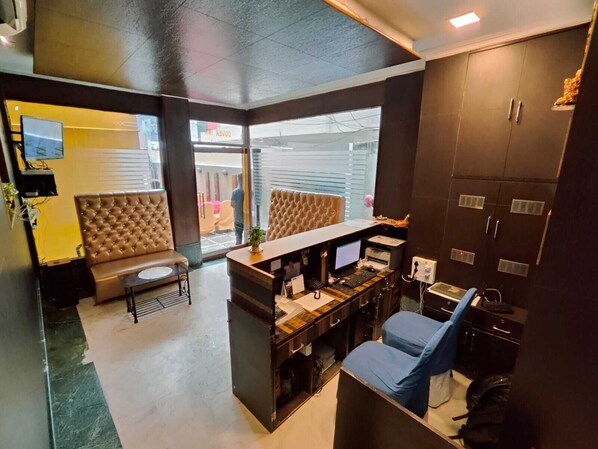 Un espacio de oficina moderno con escritorio, computadora y zona de estar.