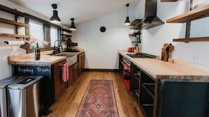 A modern kitchen with wooden cabinets, a built-in stove, and a large window. - Modern Victorian in the heart of downtown Nevada City (Nevada City)