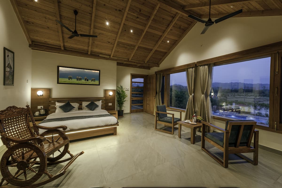 Un dormitorio espacioso con una cama grande, una mecedora de madera y vistas al exterior.