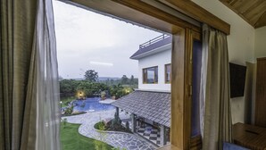 Blick auf ein Haus mit einem Kiesweg, der zu einem Pool führt, umgeben von Grünpflanzen.