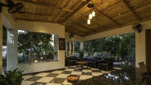 Eine großzügige Lobby mit einem Schachbrettmuster-Boden, Ledersofas, einem Couchtisch und einem großen Fenster mit Blick auf Grünflächen.