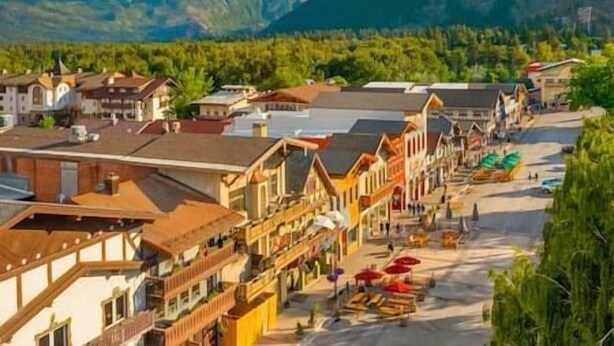 Eine Stadt mit traditioneller Architektur, einem zentralen Platz und Bergen im Hintergrund.