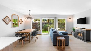 Ein moderner Wohnraum mit Essbereich, Sofa und Kamin.