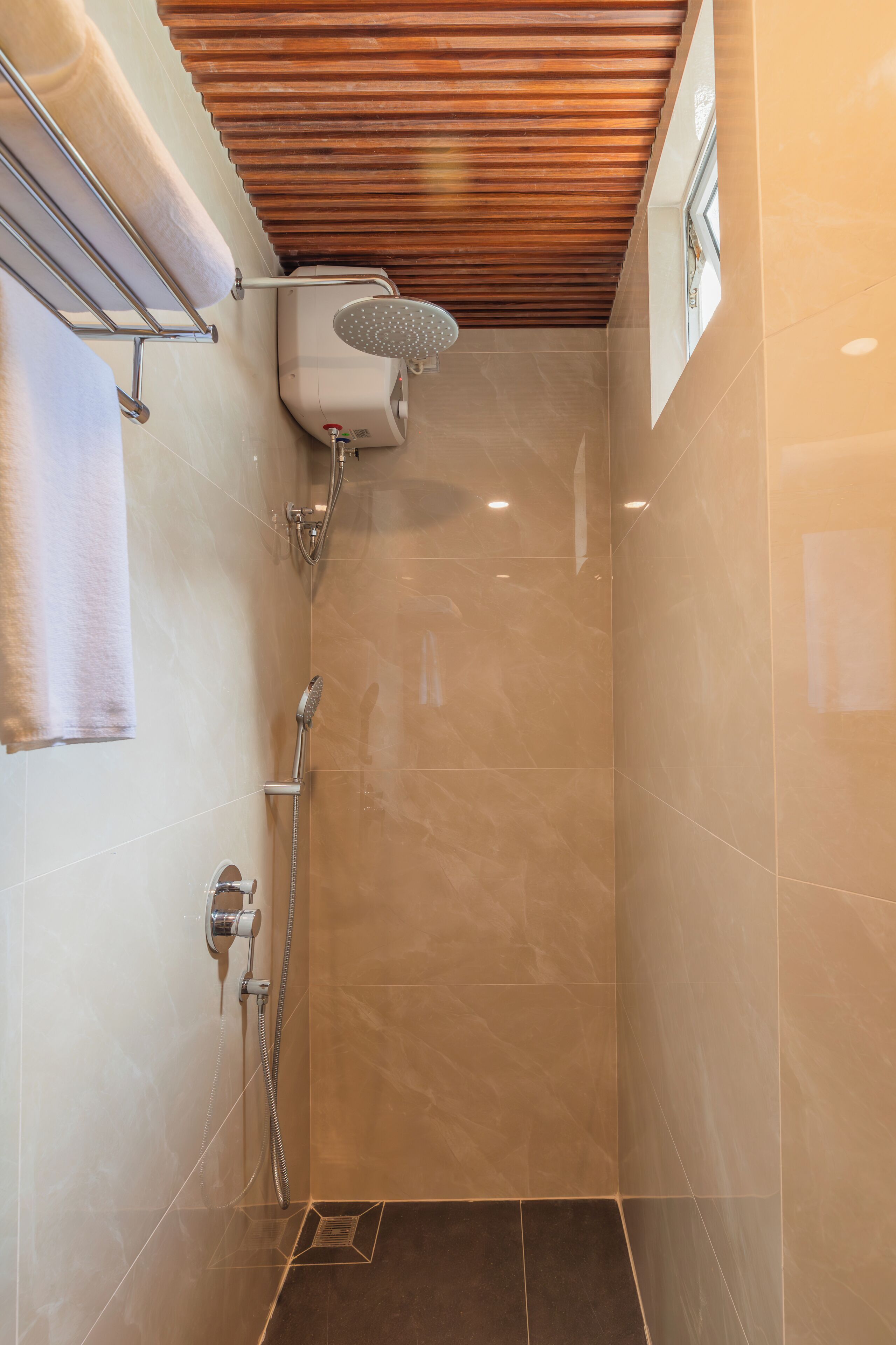 Ein modernes Badezimmer mit Dusche, gefliesten Wänden und Holzboden.