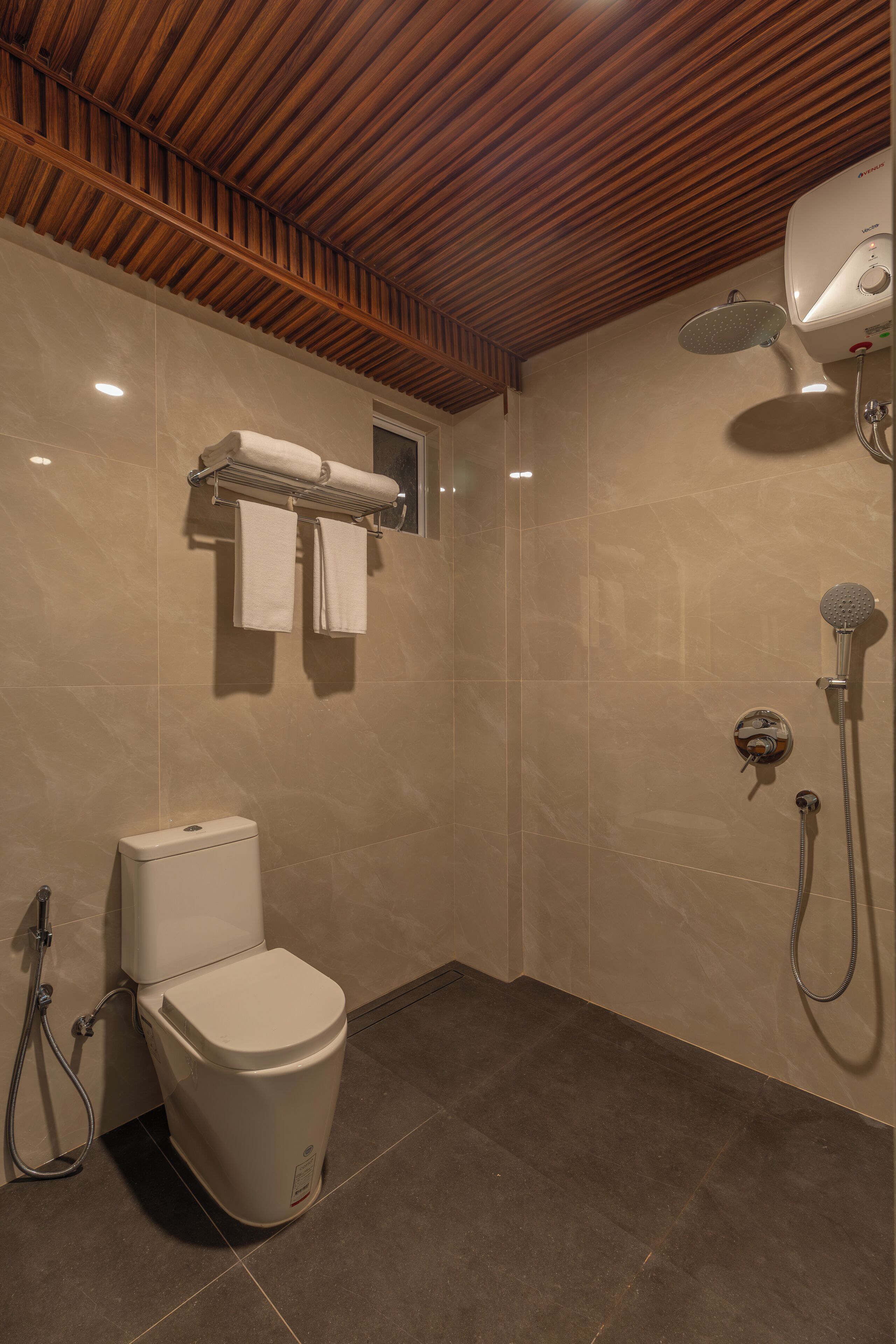 A bathroom with a toilet, a shower, and a towel rack.