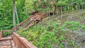 Un escalier en bois qui monte une colline dans une zone boisée.