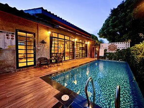 A hotel with an outdoor swimming pool, wooden deck, and seating area. - Best Way Resort (Pak Chong)