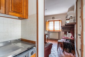 Una cocina con estufa, armarios y un comedor con mesa y sillas.