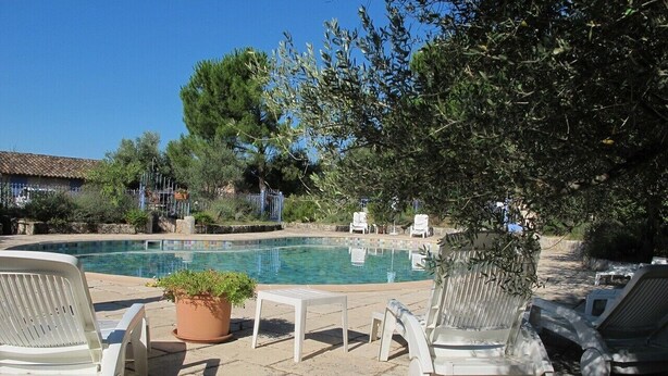 A poolside area with lounge chairs, a small table, and a potted plant.