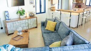 A living room with a grey sofa, a wooden coffee table, and a blue and white patterned sofa. - Villa Stefania with Pool (Rethymno)