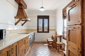 A kitchen with wooden cabinets, a sink, a stove, and a window.