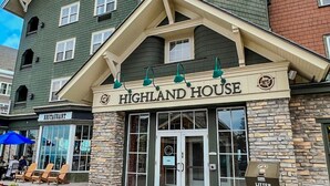 Un edificio con un letrero que dice 'HIGHLAND HOUSE' y un letrero que indica 'RESTAURANT' debajo.