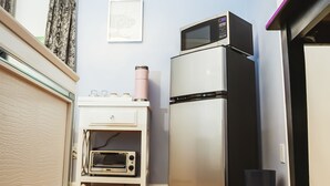Eine kleine Küche mit Mikrowelle, Toaster und Kühlschrank.