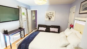 Ein Schlafzimmer mit einem Bett, Nachttischen, einem Schreibtisch und einem Fernseher.