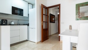A modern kitchen with white cabinets, a built-in microwave, and a coffee maker. - 'City in Fuengirola Centro' Apartment with Balcony and Wi-Fi (Fuengirola)