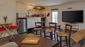 Um espaço compacto com cozinha compacta, área de refeições e um espaço para sentar.