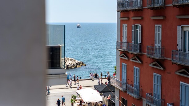 A coastal view with a building featuring balconies and a view of the sea. - Via Niccol Tommaseo 4 - Appartamento 5 (Naples)