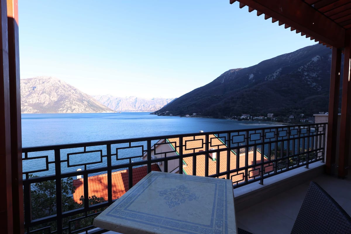 Un balcon avec vue sur un lac et des montagnes.