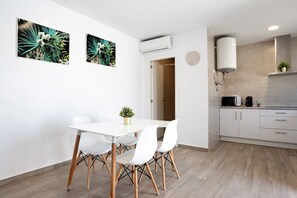 A modern kitchen with white cabinets, a white countertop, and a built-in oven.