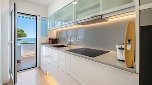 Eine moderne Küche mit einer Schiebeglasdoor zum Balkon.