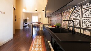 Cocina moderna con armarios oscuros, encimera negra y salpicadero con diseño.