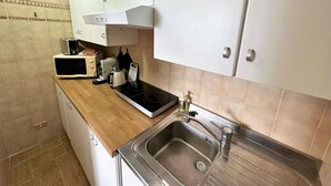 Eine Küche mit Mikrowelle, Toaster, Wasserkocher und Spüle.