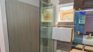 A modern bathroom with a glass-enclosed shower, a toilet, and a sink with a mirror above it. - Grand Central Hotel and Restaurant  (Angeles City)