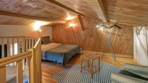 A wooden room with a bed, a small table, a ladder, and a railing. - Farmhouse in Auvergne, terrace, pets allowed (Vêtre-sur-Anzon)