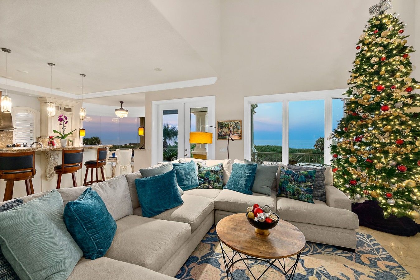 A modern living room with a large sectional sofa, a coffee table, and a Christmas tree.