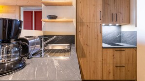 A modern kitchen with wooden cabinets, a marble countertop, and a coffee maker. - 3-room flat, 6 ppl, Southwest balcony, near slopes (Avoriaz)