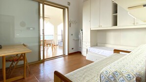 Un dormitorio con cama, escritorio y armario.
