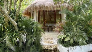 A thatched-roof structure with a stone pathway leading to a wooden door. - Bodhi Bingin (Pecatu)