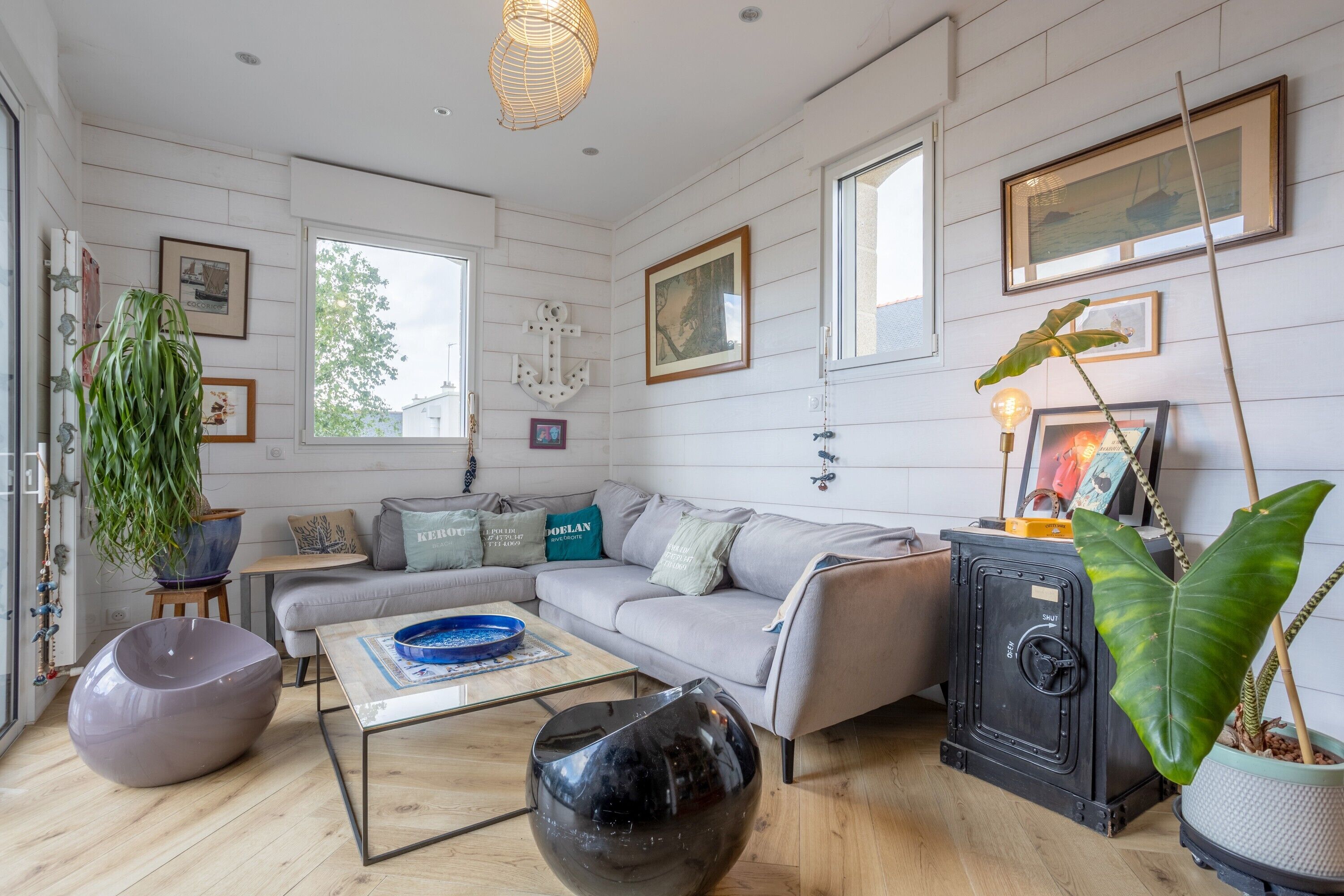 A modern living room with a sofa, coffee table, and decorative plants.