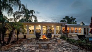 A patio with a fire pit, outdoor seating, and a pool area.