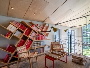 Relax in a serene reading room with high ceilings, large windows, and ample bookshelves.