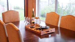 A wooden dining table with a tray containing a bottle of wine, glasses, and a jar. - Lakefront Cottage: Dock & Fire Pit- Pet Friendly (Geneva)