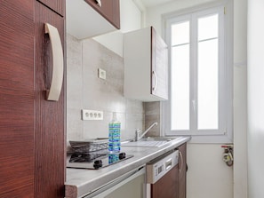 A kitchen with a stove, a dishwasher, and a window.