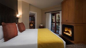 Ein Hotelzimmer mit Bett, Kamin, Fernseher und Balkon.