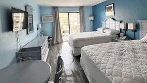 A hotel room with a bed, a desk, a chair, a window, and a door. - Oceanview Efficiency DW407 (Myrtle Beach)
