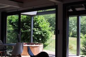 Une terrasse extérieure moderne équipée d’un jacuzzi, de chaises et d’une table.