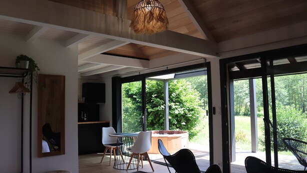Un interno moderno con zona pranzo, ampie finestre e vista sul verde.