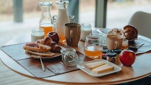 Een ontbijttafel met gebak, melk en thee.