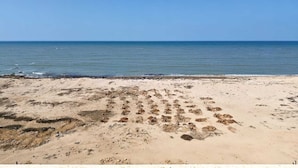 A beach with a clear sky and calm sea. - The Sky Comfort Beach Hotel, Dwarka (Dwarka)