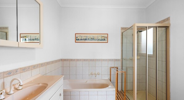 A bathroom with a bathtub, a shower, and a mirror. - Family and Spa Oasis (Cowes)