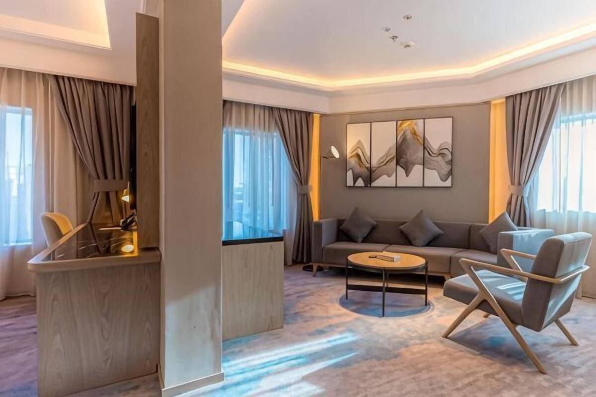 Ein modernes Hotelzimmer mit einer Couch, einem Sessel und einem kleinen Couchtisch.