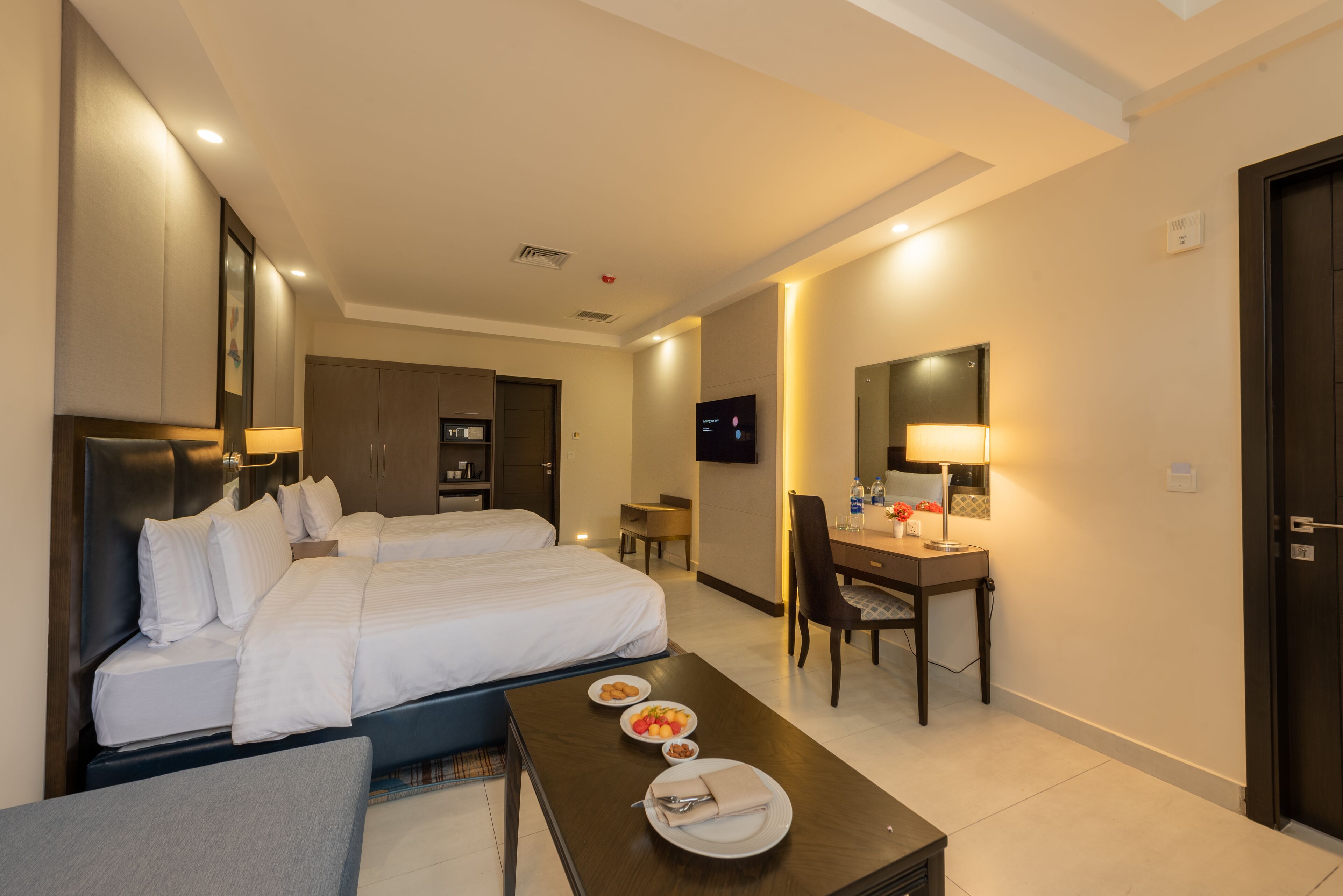Une chambre d’hôtel avec un lit, un bureau, une chaise et un téléviseur.